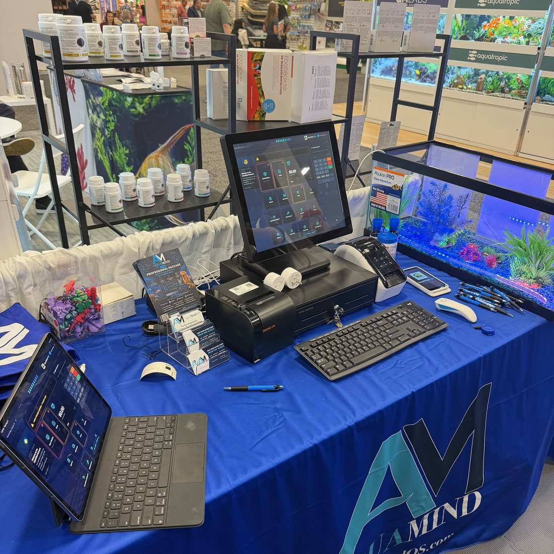 AquaMind OS register running the live dashboard at a store counter, with receipt printer, cash drawer and a dashboard tablet